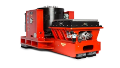Ein großes, rotes industrielles Prüfsystem der Marke RMS, bestehend aus einem zentralen Shaker-Tisch mit schwarzem Zylinder, einer linken Steuereinheit mit RMS-Logo und einer rechten Hydraulikeinheit, freigestellt auf weißem Hintergrund.
