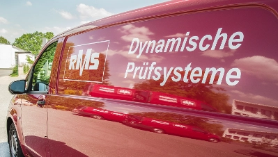 Roter RMS Service-Transporter mit der weißen Aufschrift ‚Dynamische Prüfsysteme‘ auf der Seitenwand.